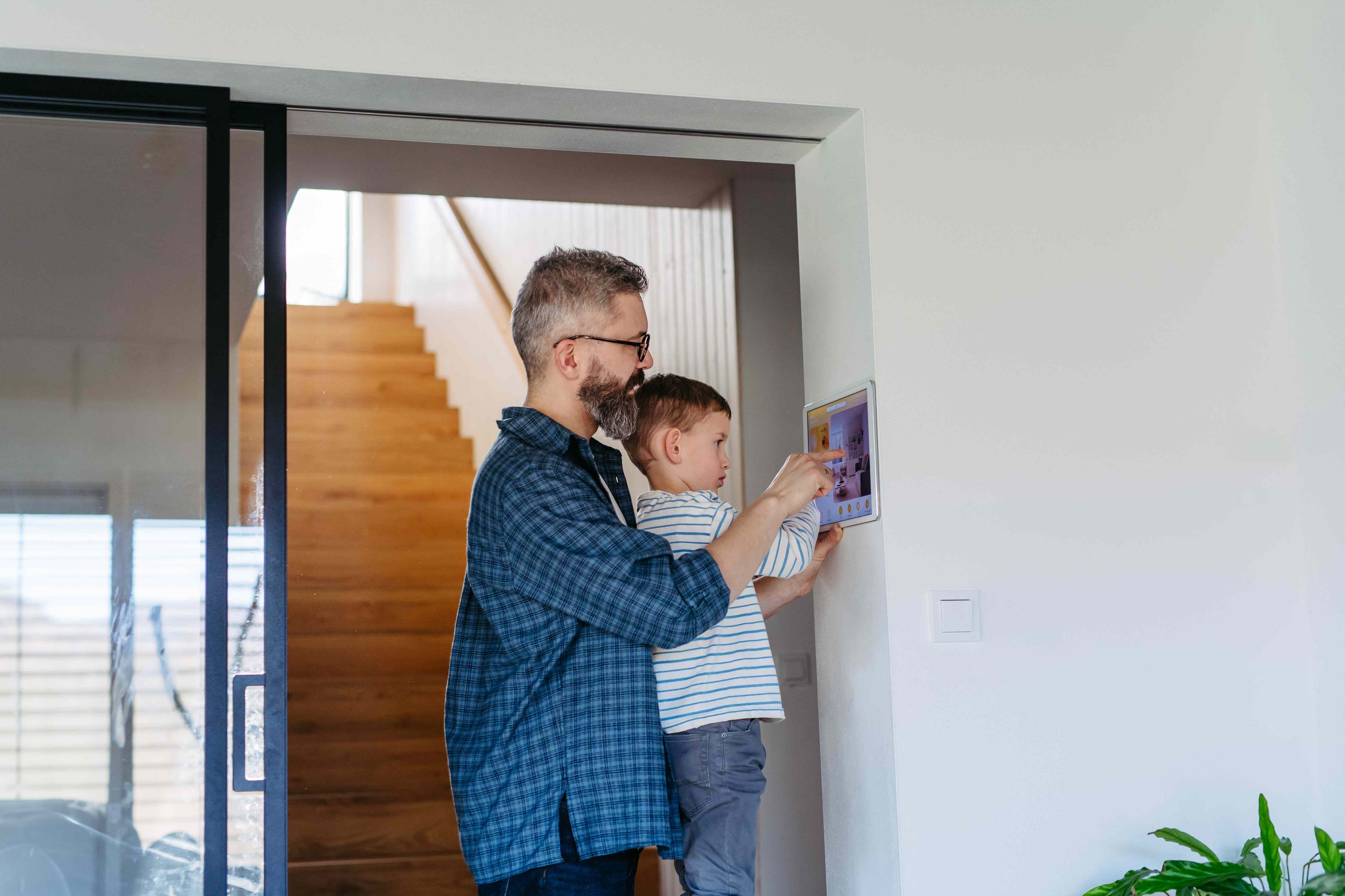 Father and son using a smart home security panel